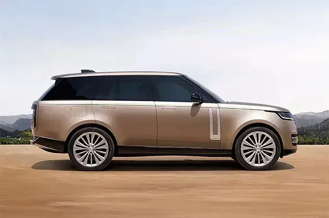 سيارة SUV فاخرة باللون الذهبي جانبية على أرض رملية
