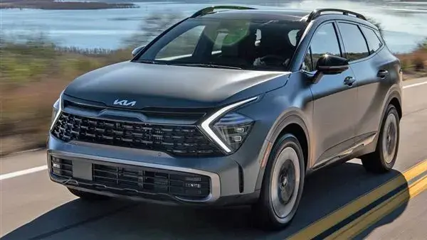 سيارة كيا SUV رمادية من الأمام أثناء السير على طريق بجوار بحيرة