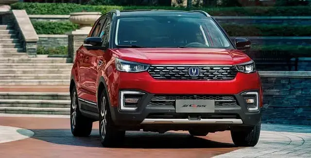 سيارة SUV حمراء من شانجان من الأمام بجوار درج وحديقة