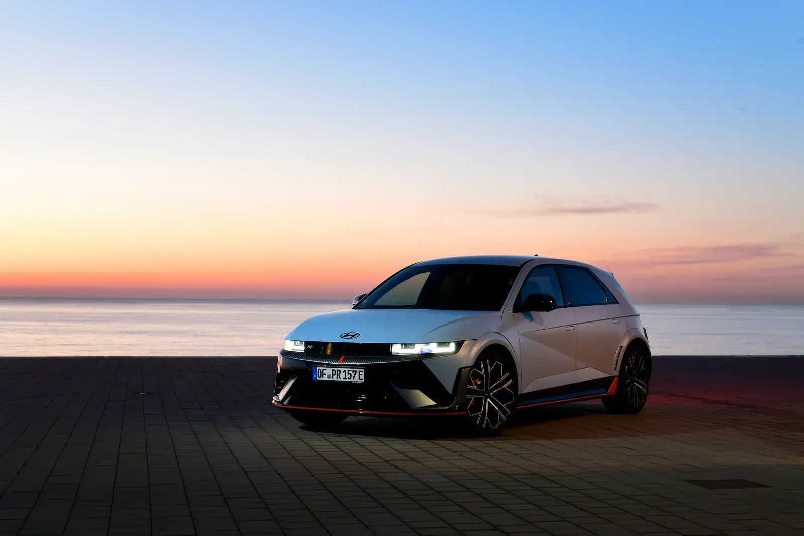 هيونداي IONIQ 5N الكهربائية باللون الرمادي من الأمام على شاطئ البحر وقت الغروب