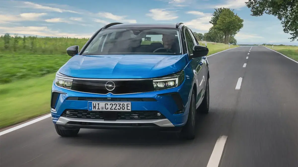سيارة أوبل SUV زرقاء من الأمام أثناء السير على طريق ريفي