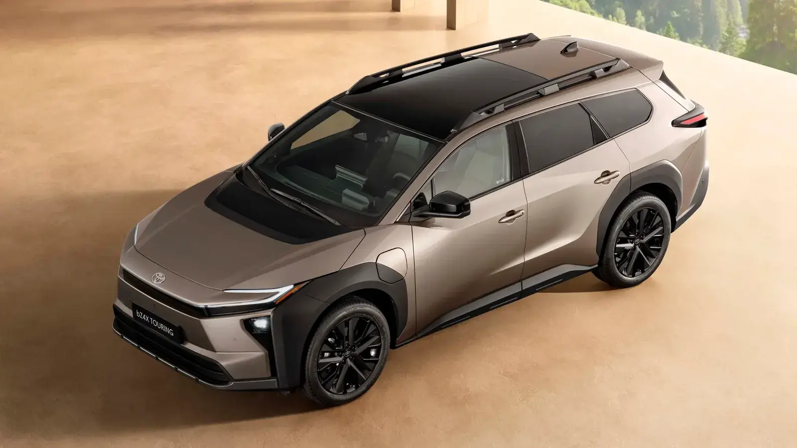 تويوتا bZ4X Touring الكهربائية باللون البيج من الأمام بزاوية علوية مع سقف أسود وقضبان سقف