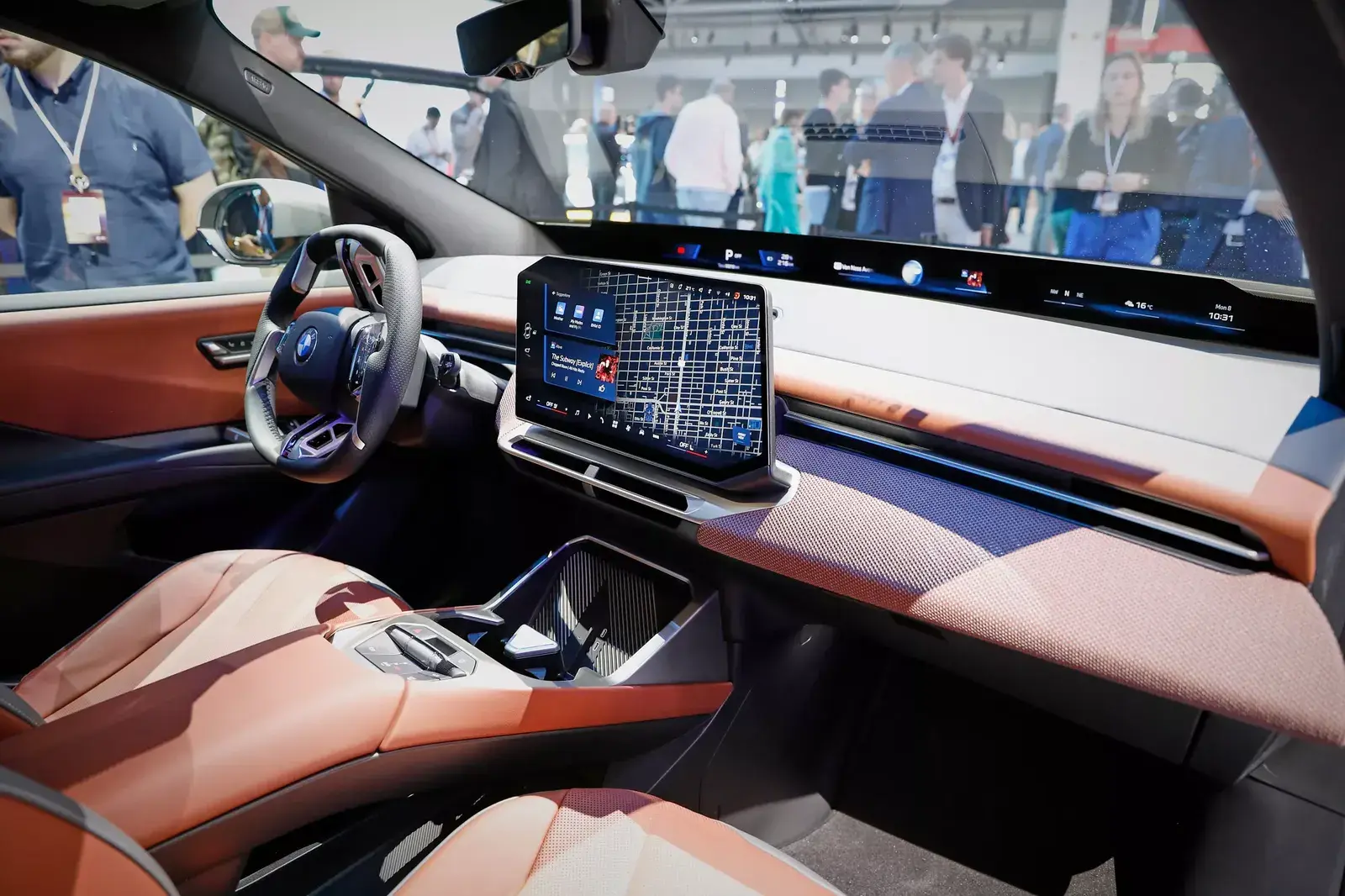 مقصورة BMW iX3 بمقاعد بلون بني وشاشة وسطية كبيرة خلال عرضها في أحد المعارض
