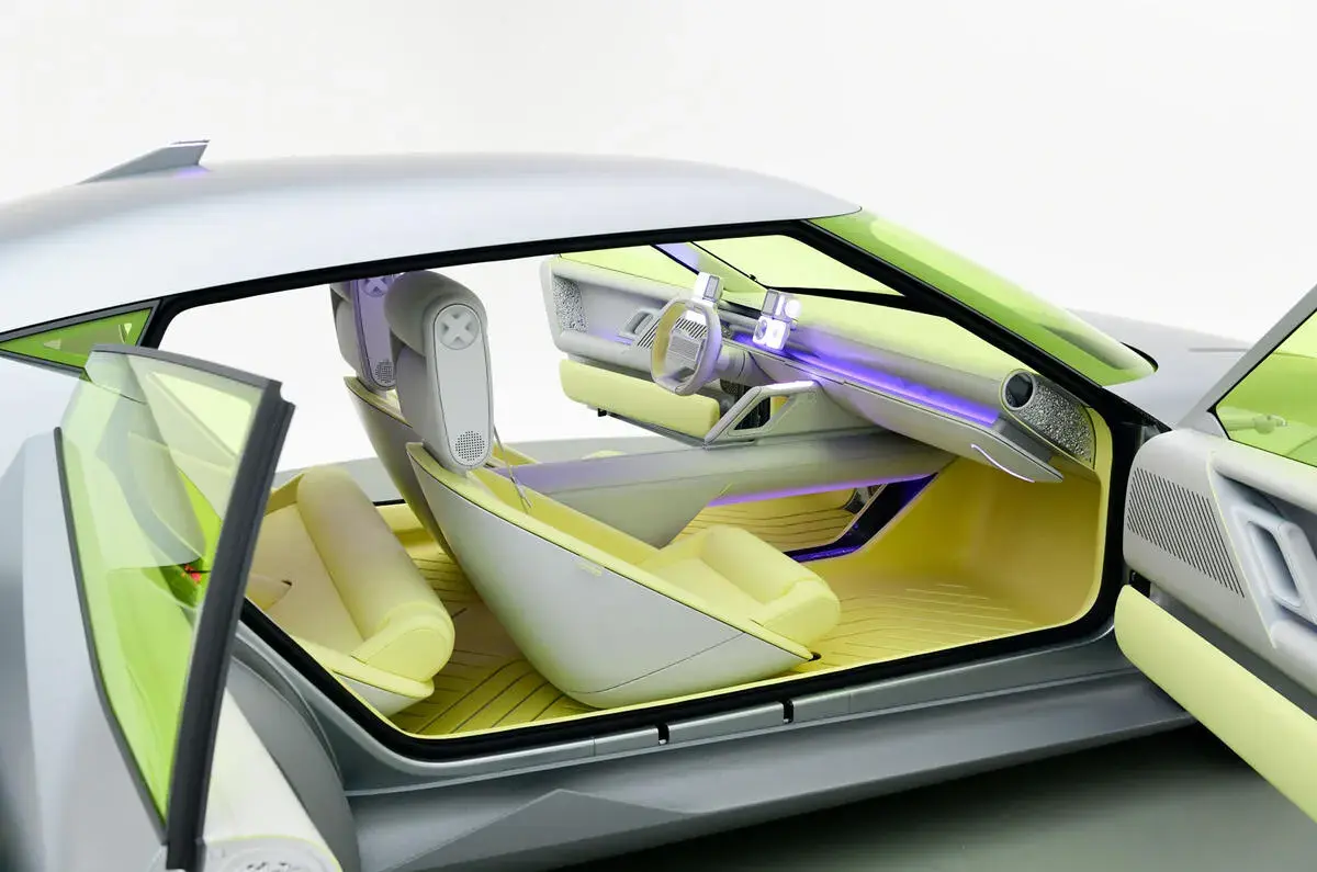 مقصورة هيونداي Concept Three الكهربائية بأبواب مفتوحة ومقاعد صفراء فاتحة وإضاءة بنفسجية