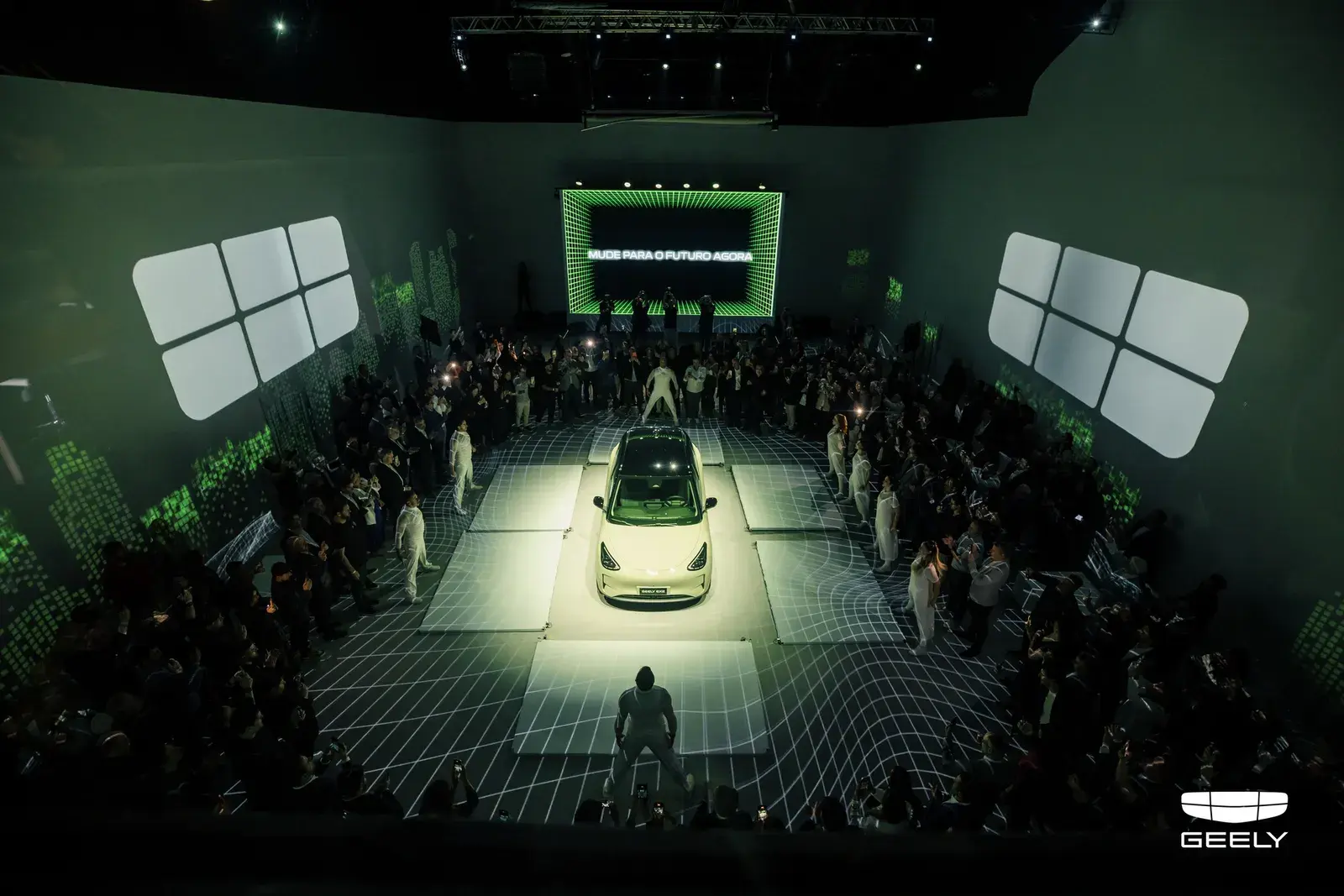 سيارة جيلي كهربائية بيضاء وسط الحضور خلال حفل إطلاق بإضاءة خضراء
