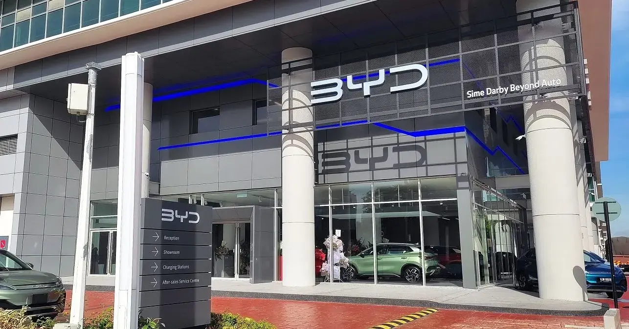 واجهة صالة عرض ومركز خدمة BYD مع لافتة الاستقبال والصيانة وسيارات خلف الزجاج
