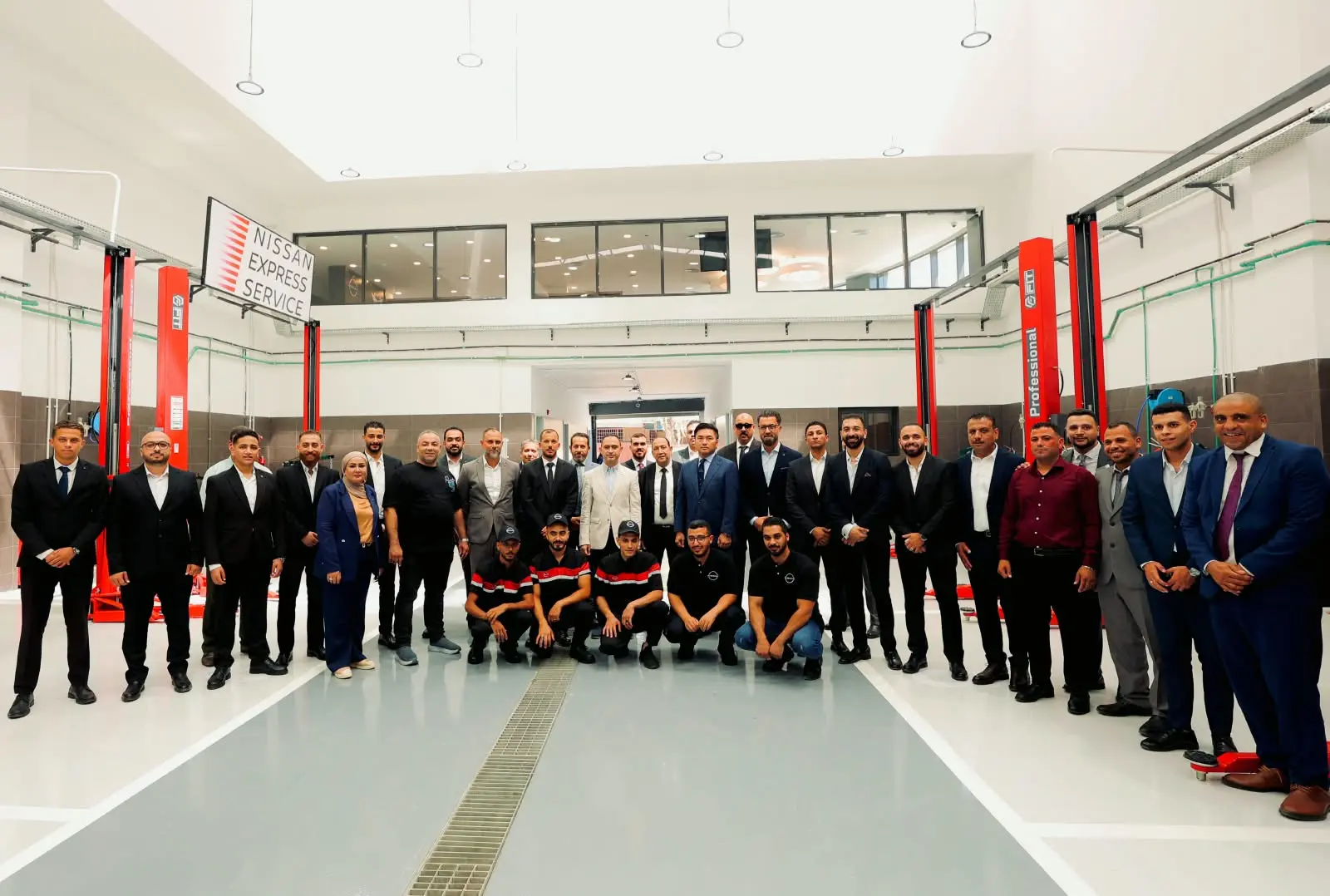 فريق نيسان ووكيل AMG Motors في صورة جماعية داخل ورشة خدمة نيسان السريعة بدمياط الجديدة