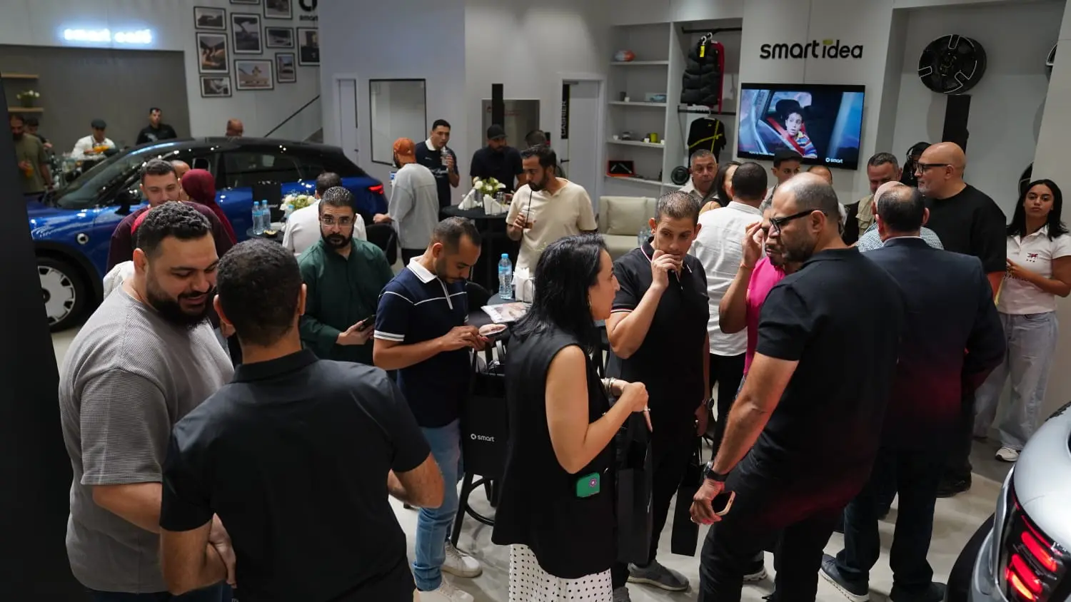 حضور افتتاح صالة عرض سيارات smart في District 5 بجوار سيارة زرقاء