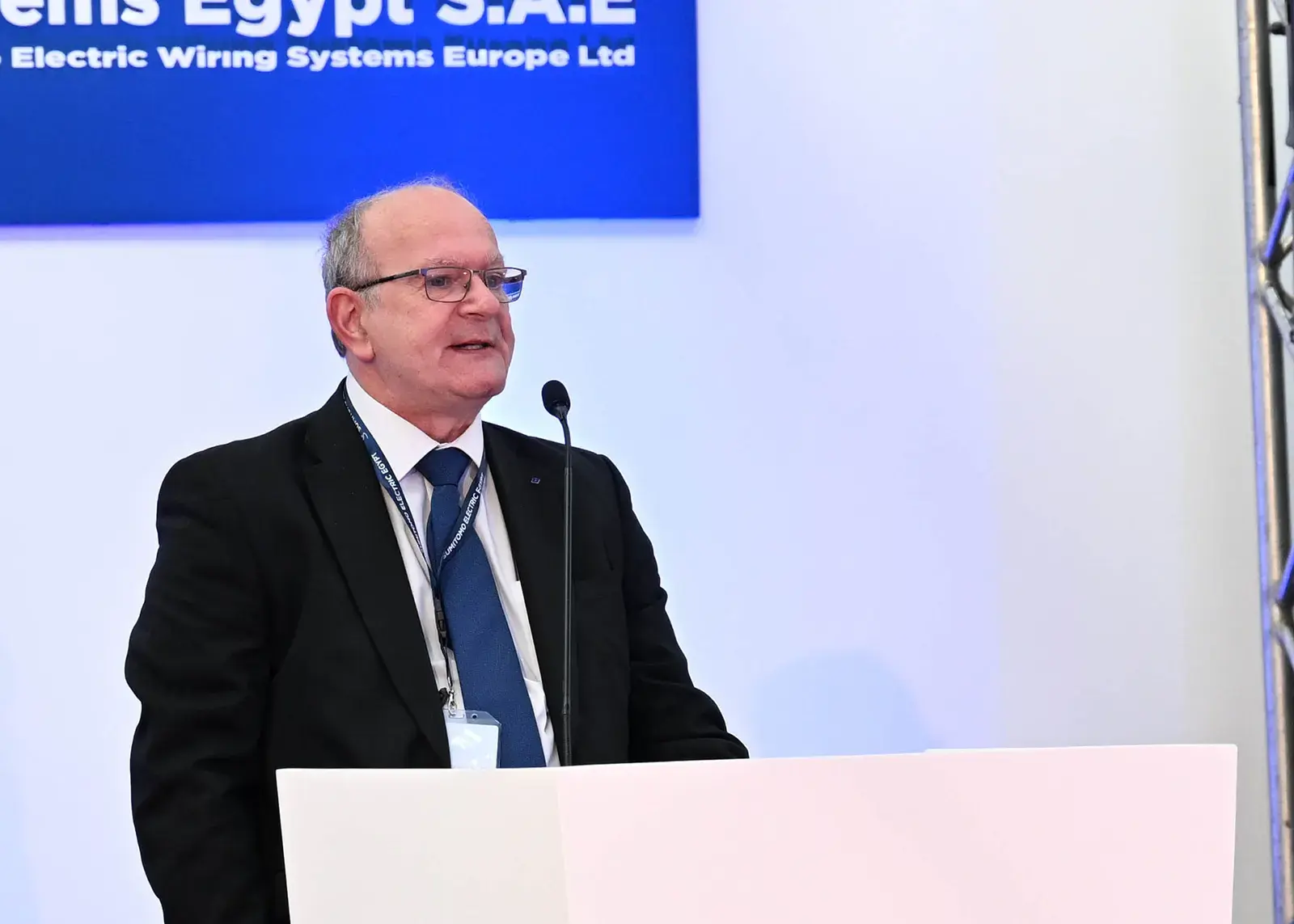 متحدث يلقي كلمة أمام شعار الشركة خلال حفل افتتاح مصنع سوميتومو