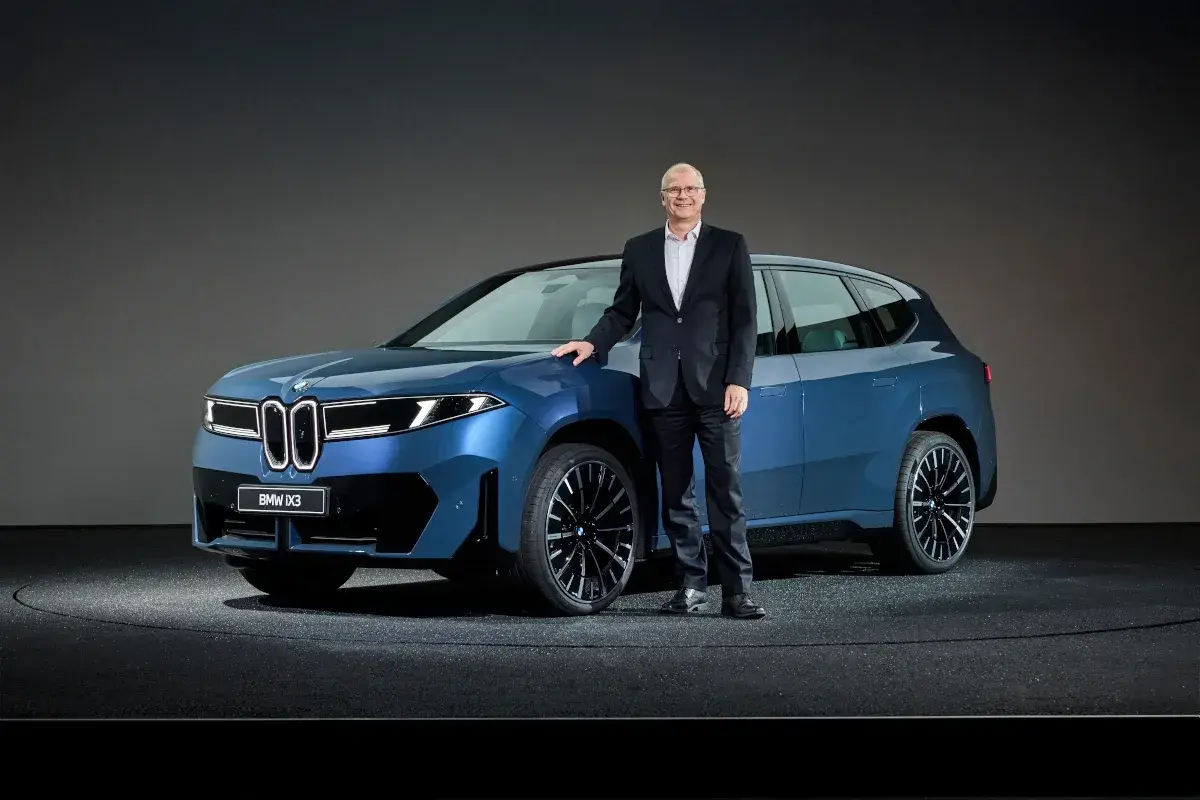 مسؤول من BMW يقف بجوار iX3 الكهربائية الزرقاء