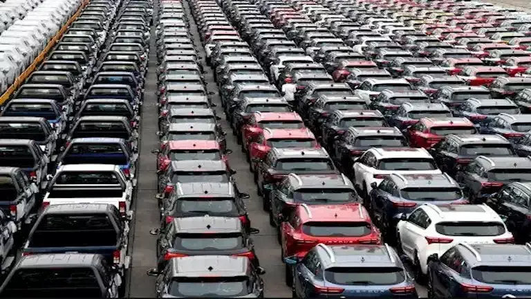 صفوف متراصة من سيارات SUV وبيك أب جديدة بألوان متعددة في ساحة تخزين مفتوحة