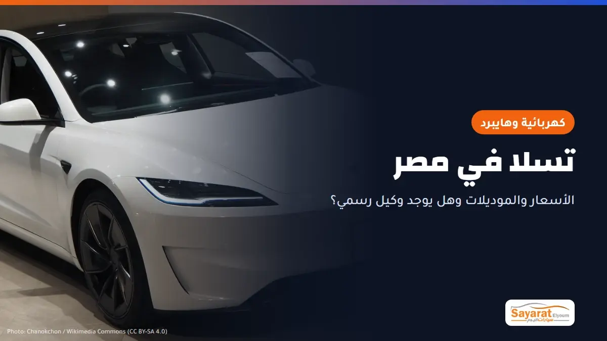 تسلا في مصر: تسلا موديل 3 بشكلها الحالي بفئة Performance بلون أبيض داخل صالة عرض، بمصابيح أمامية نحيفة وجنوط داكنة ولوحة أمامية مكتوب عليها MODEL 3