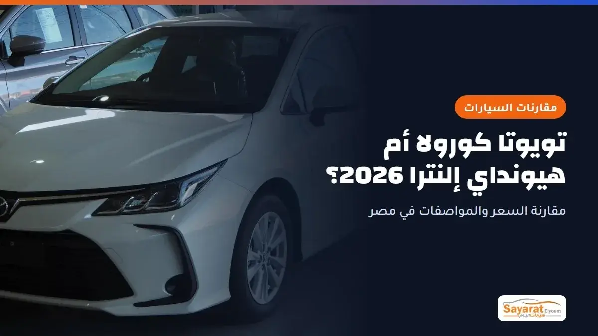 تويوتا كورولا أم هيونداي إلنترا 2026؟: تويوتا كورولا سيدان بيضاء من الجيل الحالي بمحرك 1.6 لتر داخل صالة عرض، تظهر من الأمام بزاوية جانبية بمصابيحها الأمامية الحادة وشبكتها السوداء